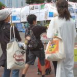 桜木町駅前で、カジノ反対ポスターのシール投票